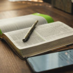 Revered Spurgeon Study Bible with iPhone on Wood Desk