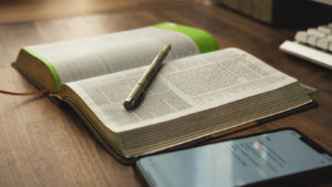 Revered Spurgeon Study Bible with iPhone on Wood Desk